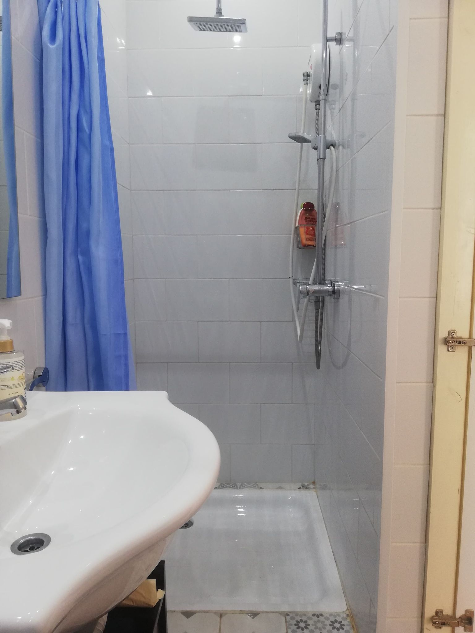 Bathroom view to the shower with blue curtain