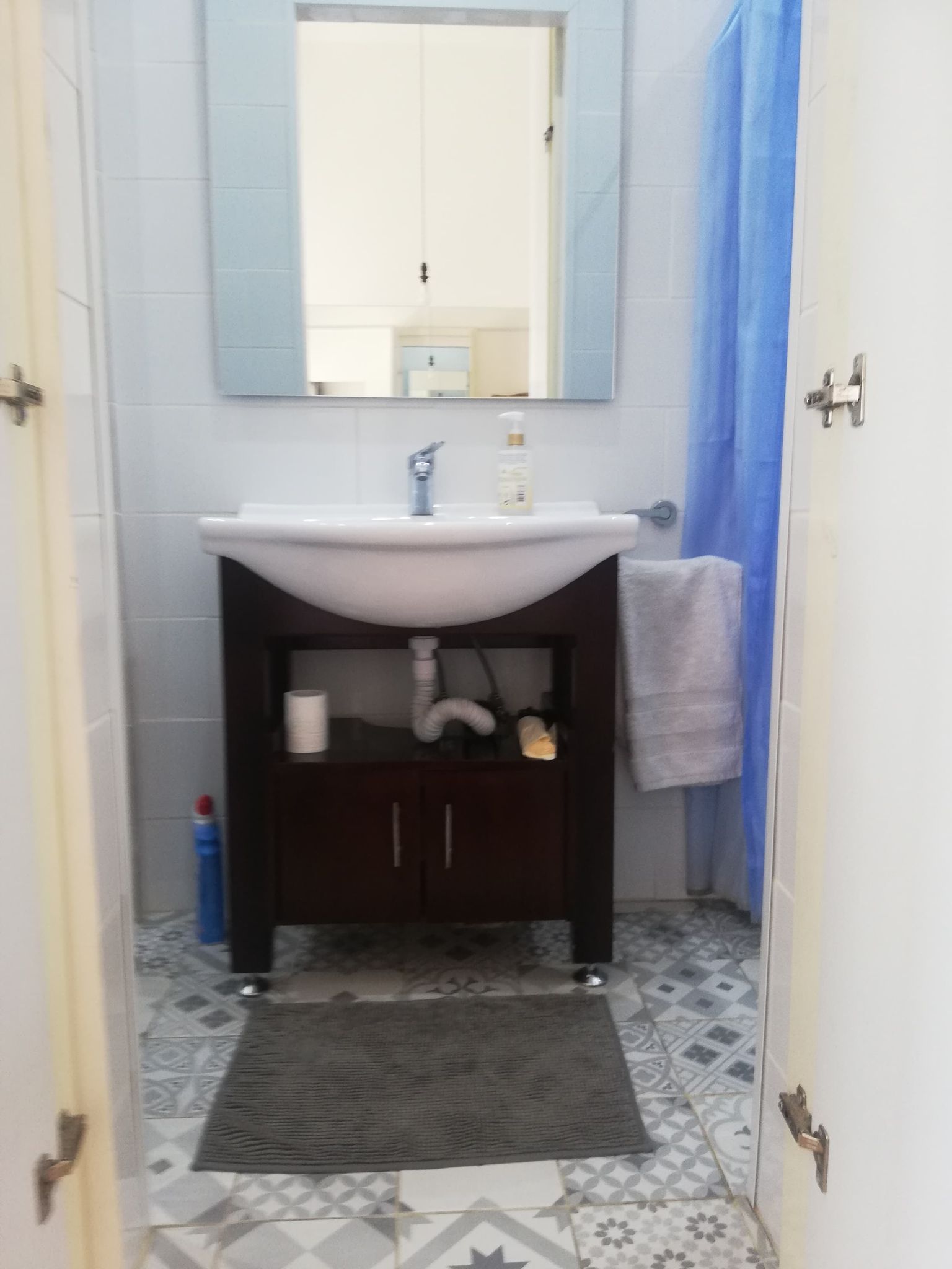 Bathroom view of the sink with mirror on the top and floor mat